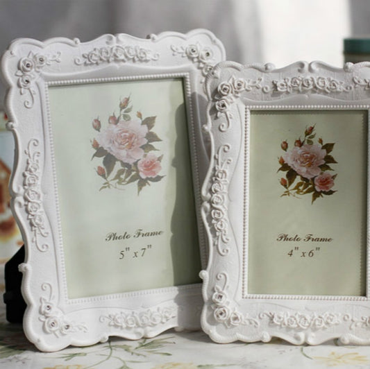 Pair of white carved floral picture frames with rose bouquet and easel bases
