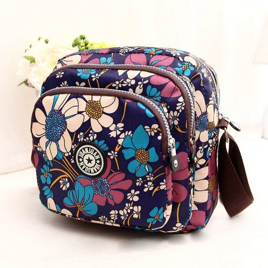 Women’s floral waterproof nylon crossbody bag with front zips, round logo, brown strap