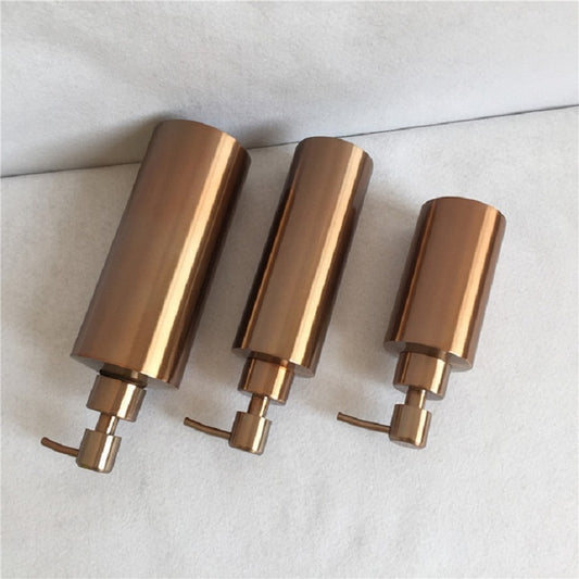 Set of three brushed bronze countertop soap dispensers with pumps