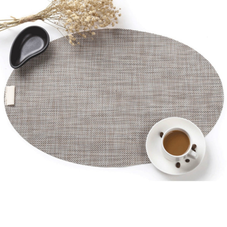 Oval PVC dining table mat in linen beige fabric, with cup and saucer on it