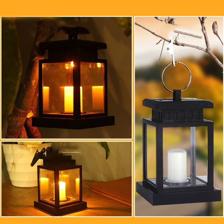 Black lantern-style LED candle light close-up with warm glowing candles behind glass