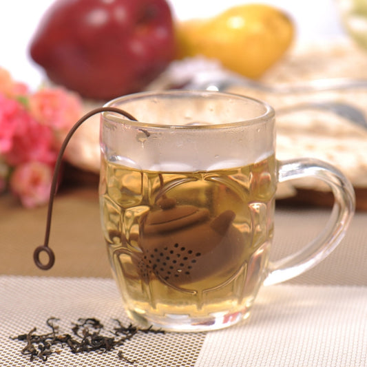Tea cup with perforated teapot-shaped silicone tea infuser floating in water