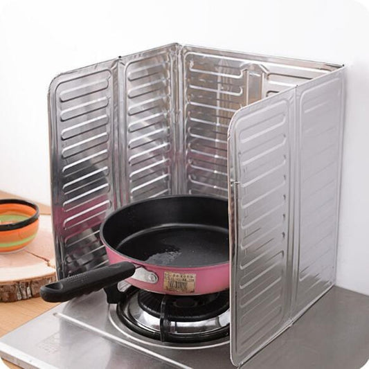 Stainless steel cooktop oil shield with folding panels around a frying pan