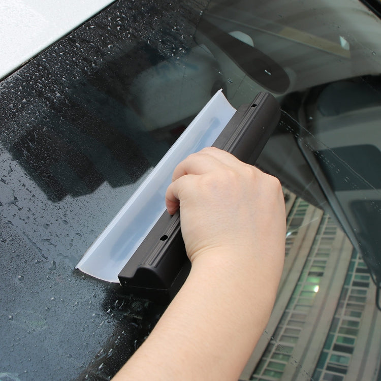 White blade with black housing water scraper removing droplets from car glass