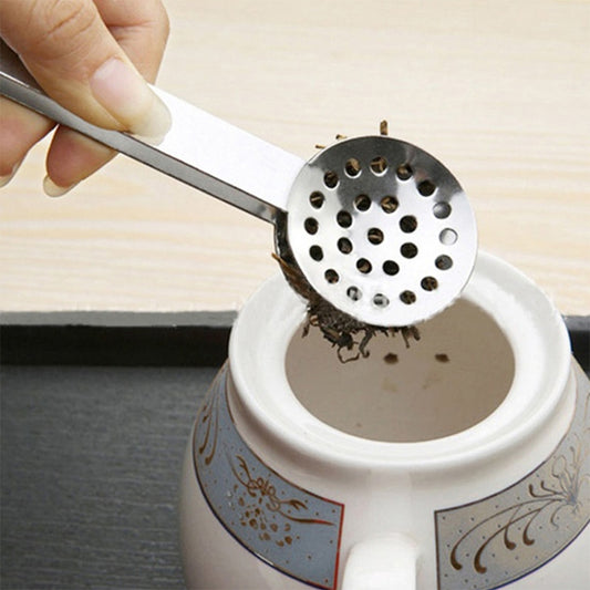 Stainless steel tea bag tong squeezer with round perforated head held over cup