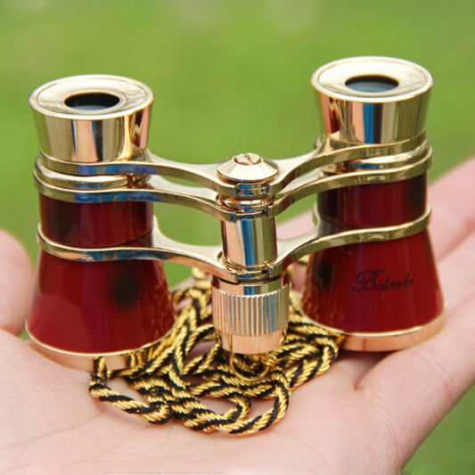 Gold-trimmed red binocular-style mini telescope with central knob and braided chain