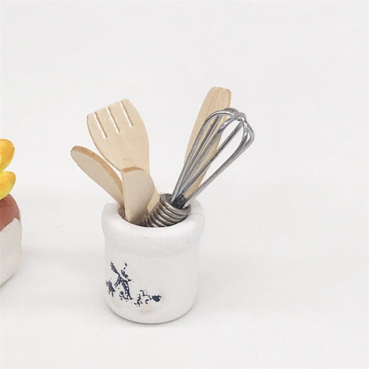 Mini kitchen utensil set close-up: white crock with metal whisk and wooden spatulas