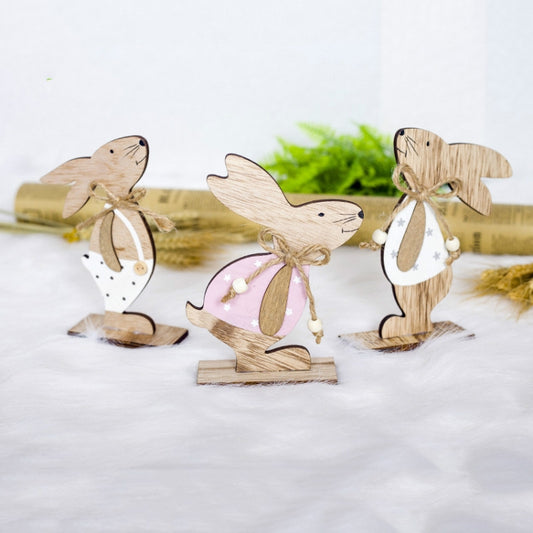 Wooden bunny ornaments with twine bows, featuring pink and white apron details on bases