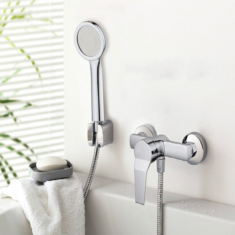 Chrome handheld shower head on flexible hose near wall-mounted faucet