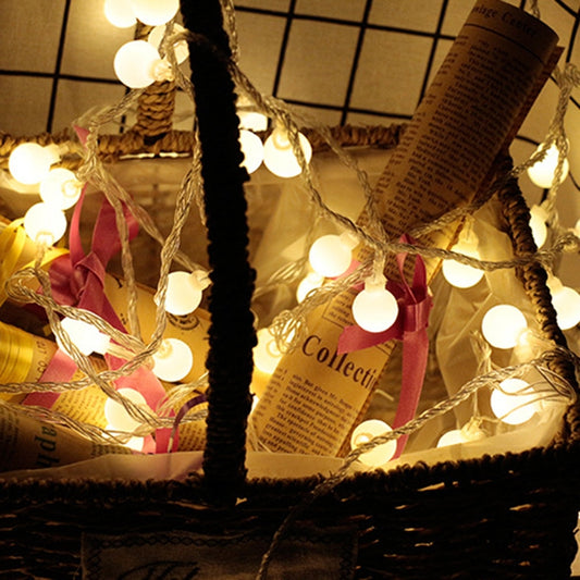 LED ball light string with warm white glowing bulbs on twisted wire, festival style
