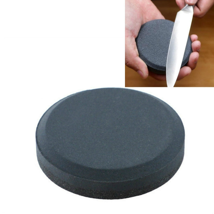 Round dark gray whetstone knife sharpener with knife sharpening motion