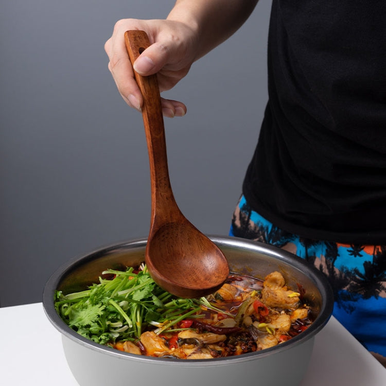 Hand holding a wooden long-handled spoon stirring food in a metal pan