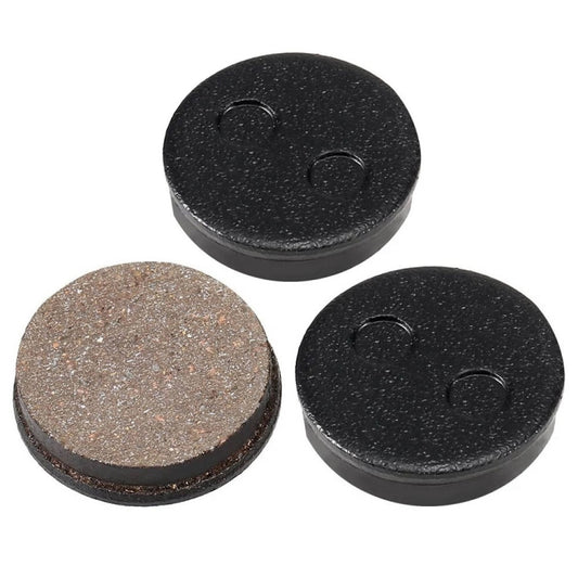 Set of 3 disc brake pads: two black and one brown friction face with black backing