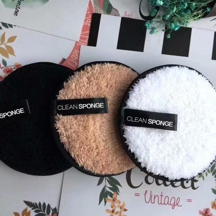 Three round microfiber cleansing puffs—black, beige, and white with black labels.