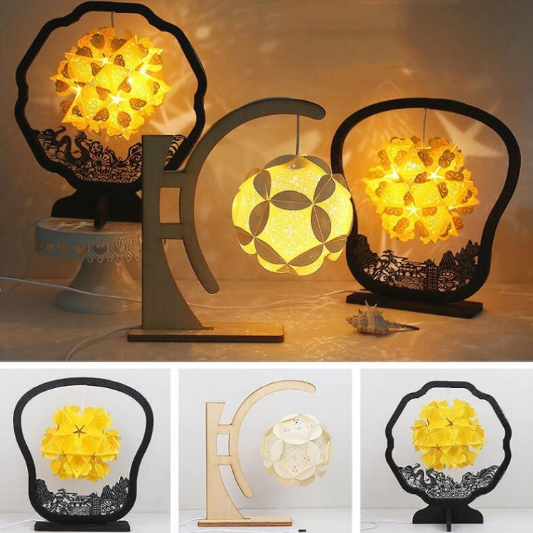 Paper carving shadow lamp with arc stand and round shade, yellow paper glow on table