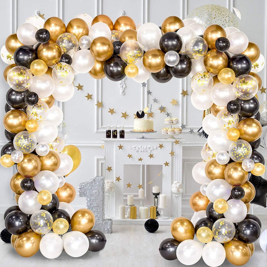 Gold, black, white balloon arch with gold star confetti and hanging decor