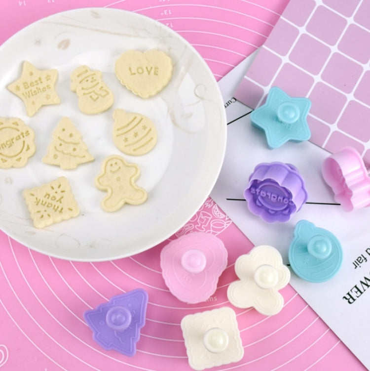 Embossed fondant cookies on a plate with blue and purple push molds nearby