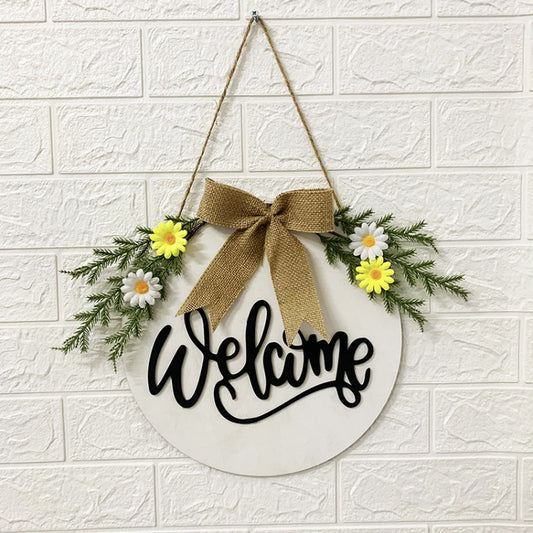 White hanging door wreath sign with “welcome,” burlap bow, and daisy flowers