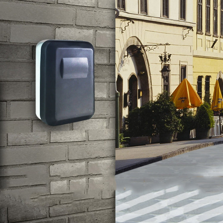 Wall-mounted password key box on a wall, dark gray with lock cover