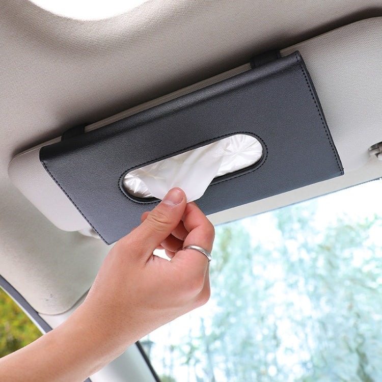 Black car visor tissue box holder with tissue pulled through oval opening