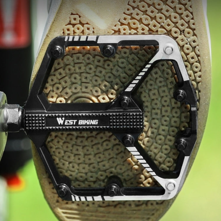 Bicycle platform pedal with metal pins and West BIKING logo, shown on shoe sole