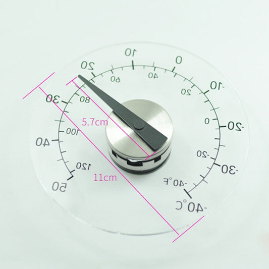 Round outdoor thermometer dial with measurement markings; black indicator hand on glass