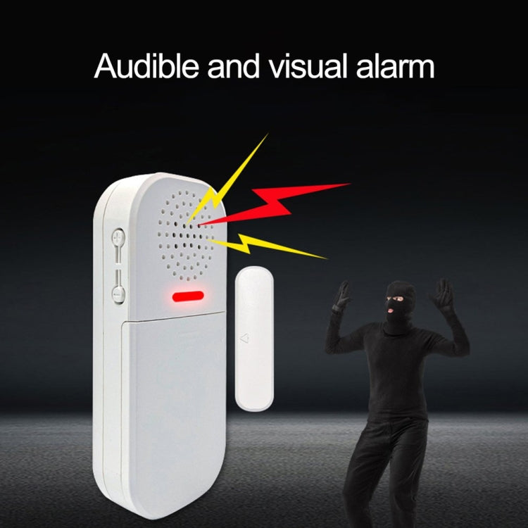 White door alarm with speaker grille and red visual indicator light, remote nearby.