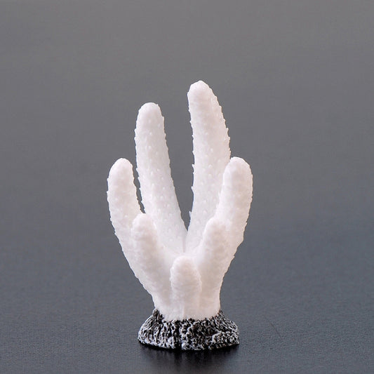 White resin coral aquarium ornament with textured black rock base.