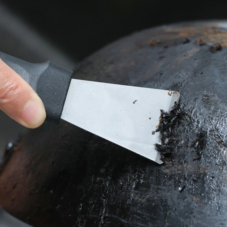 Metal-blade defrosting scraper loosening grime from a freezer surface