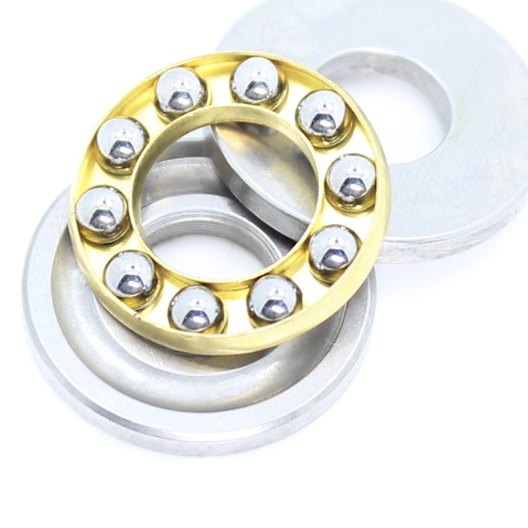 Thrust ball bearing close-up with gold ring, silver washers, and metal balls