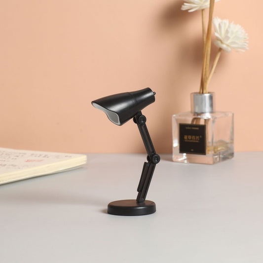 Black LED mini magnetic desk lamp with foldable adjustable arm and base.