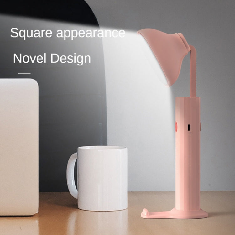 Pink folding flashlight desk lamp standing on tabletop with bright top light