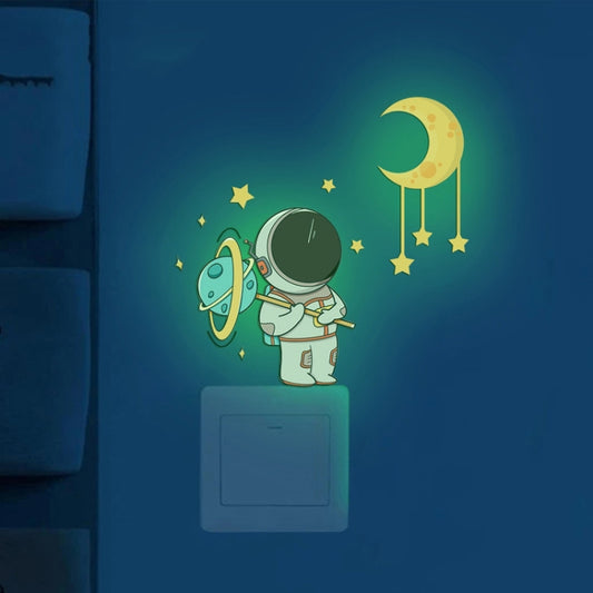 Neon green astronaut and crescent moon glow stickers above an outlet panel