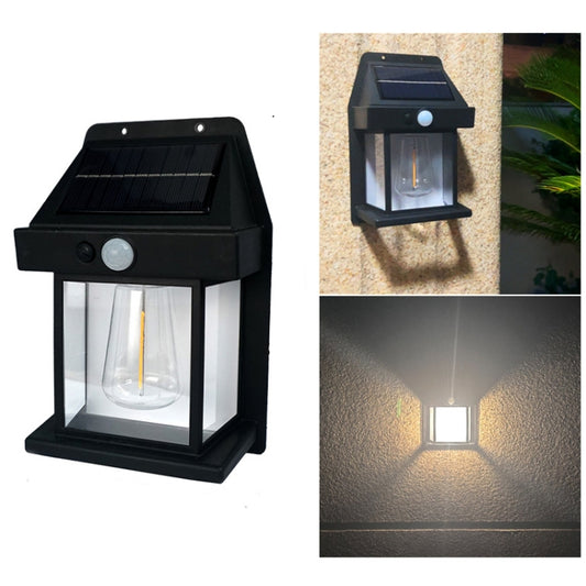 Black solar wall light showing round sensor and glass lantern, lit on wall