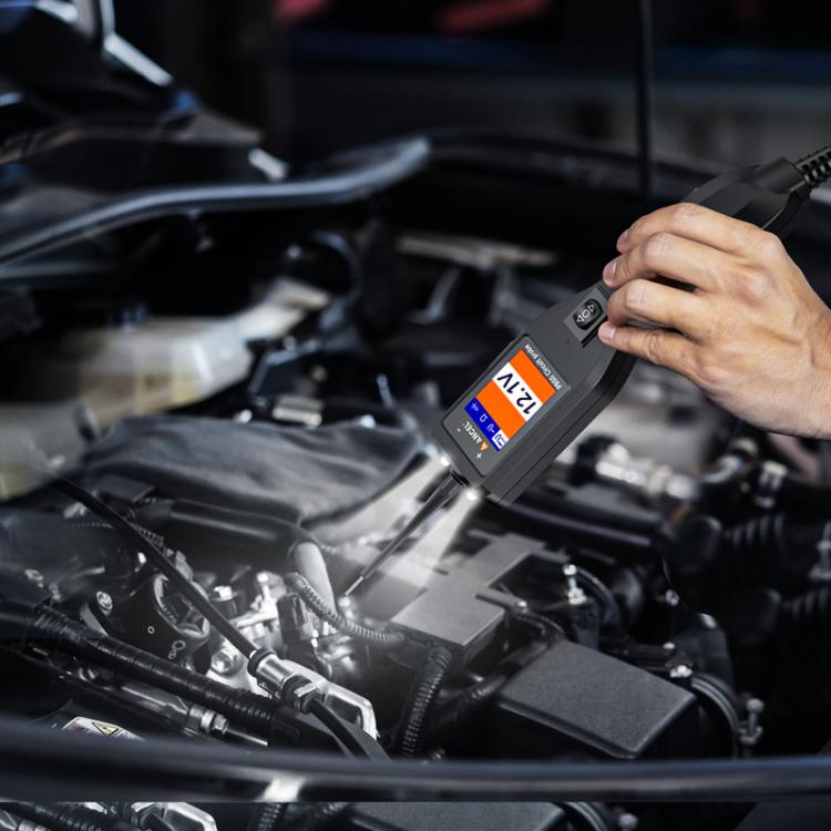 Handheld 12/24V circuit probe tester with screen and connected lead probing near engine parts