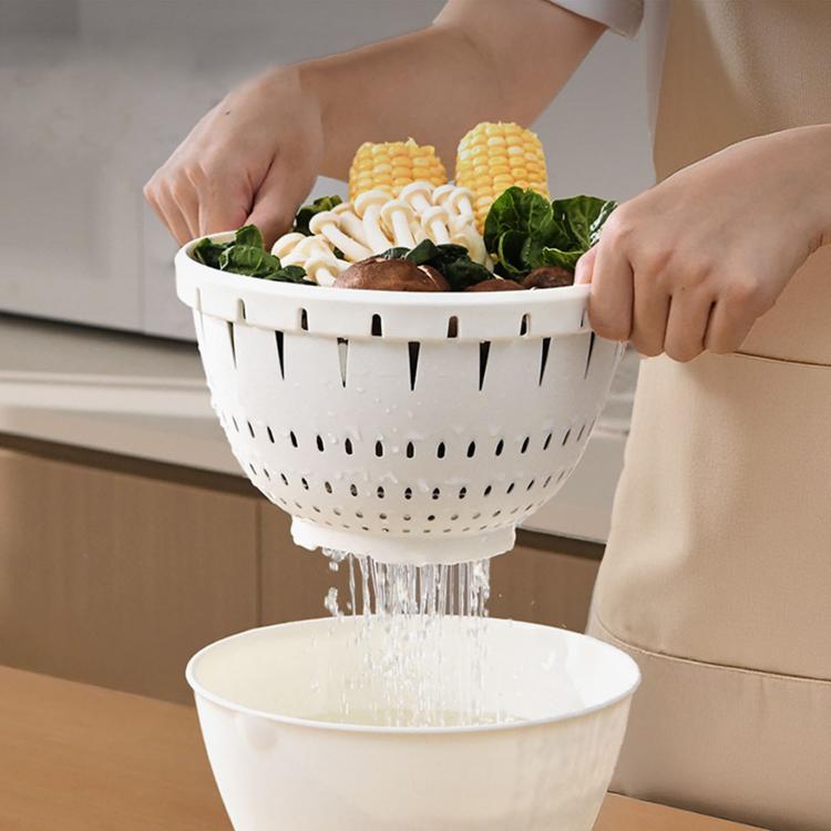 Double-layer washing and draining basket draining vegetables and noodles into a white basin