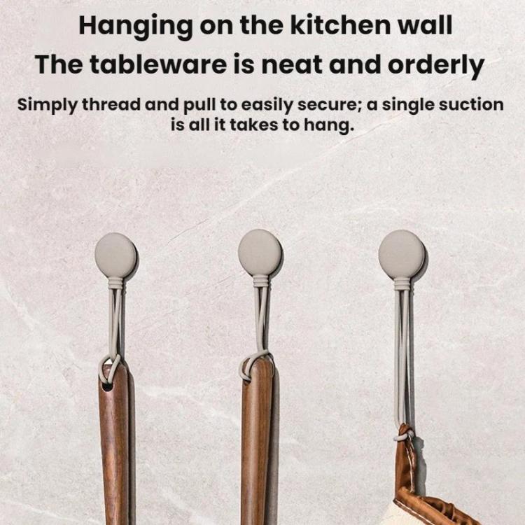 Three hanging silicone cord organizers on a kitchen wall with loop bases