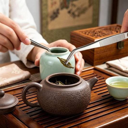 Stainless steel tea tongs with ridged tips, holding tea leaves above a kettle