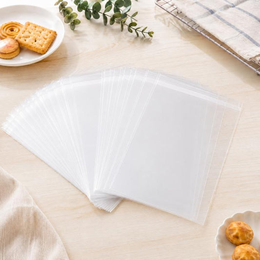 Clear self-sealing cellophane bags with top flap, empty, laid flat in a row