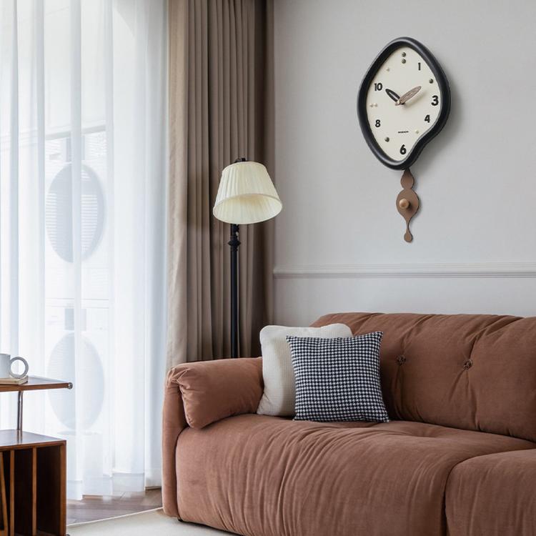 Black irregular wall clock with pendulum, white dial and gold hour markers