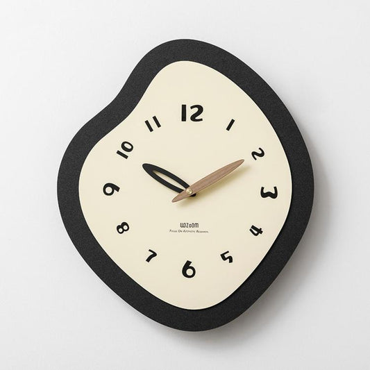 Irregular wall clock with black frame, cream dial, and gold hour and minute hands.