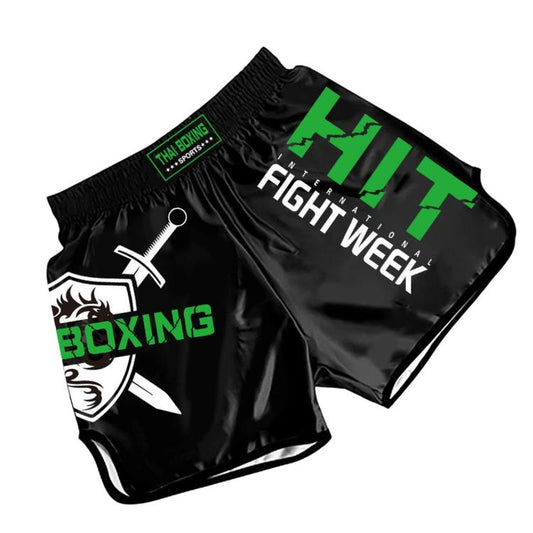 Muay Thai boxing shorts, black with green graphics and “Fight Week” print