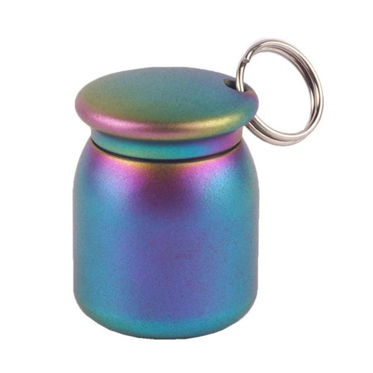 Iridescent rainbow metal pill case keychain with ring and snap lid, colorful finish.