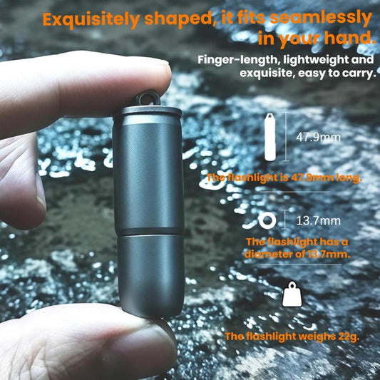 Mini pocket flashlight with key ring, held in hand, matte metallic cylinder