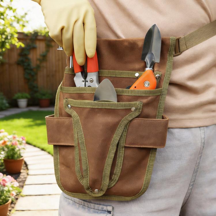 Waxed canvas waist bag holding hand tools in front pockets with elastic tool slots