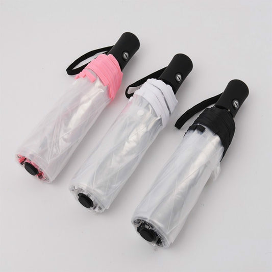 Transparent folding umbrellas in pink and white, folded with black strap handles