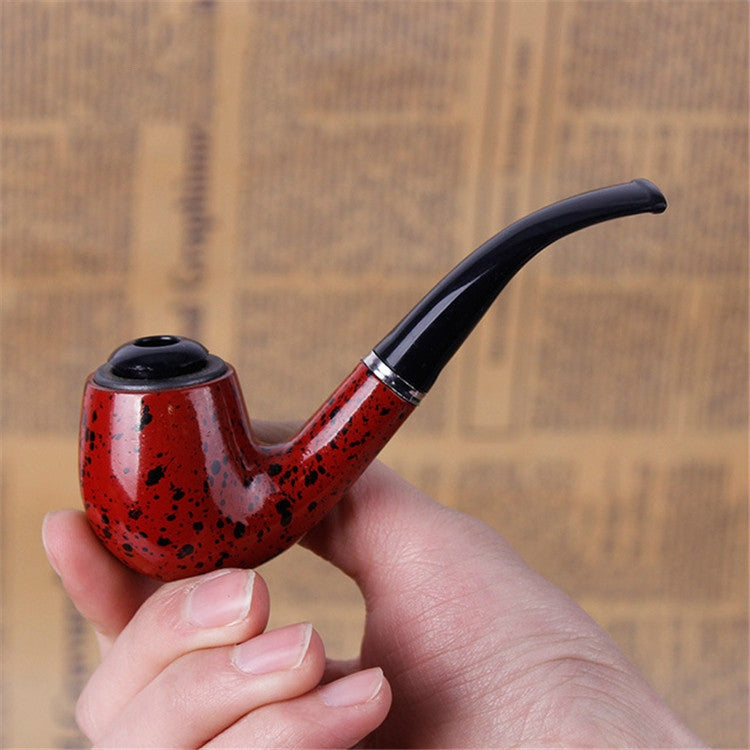 Red speckled resin mini smoking pipe with black mouthpiece, close-up