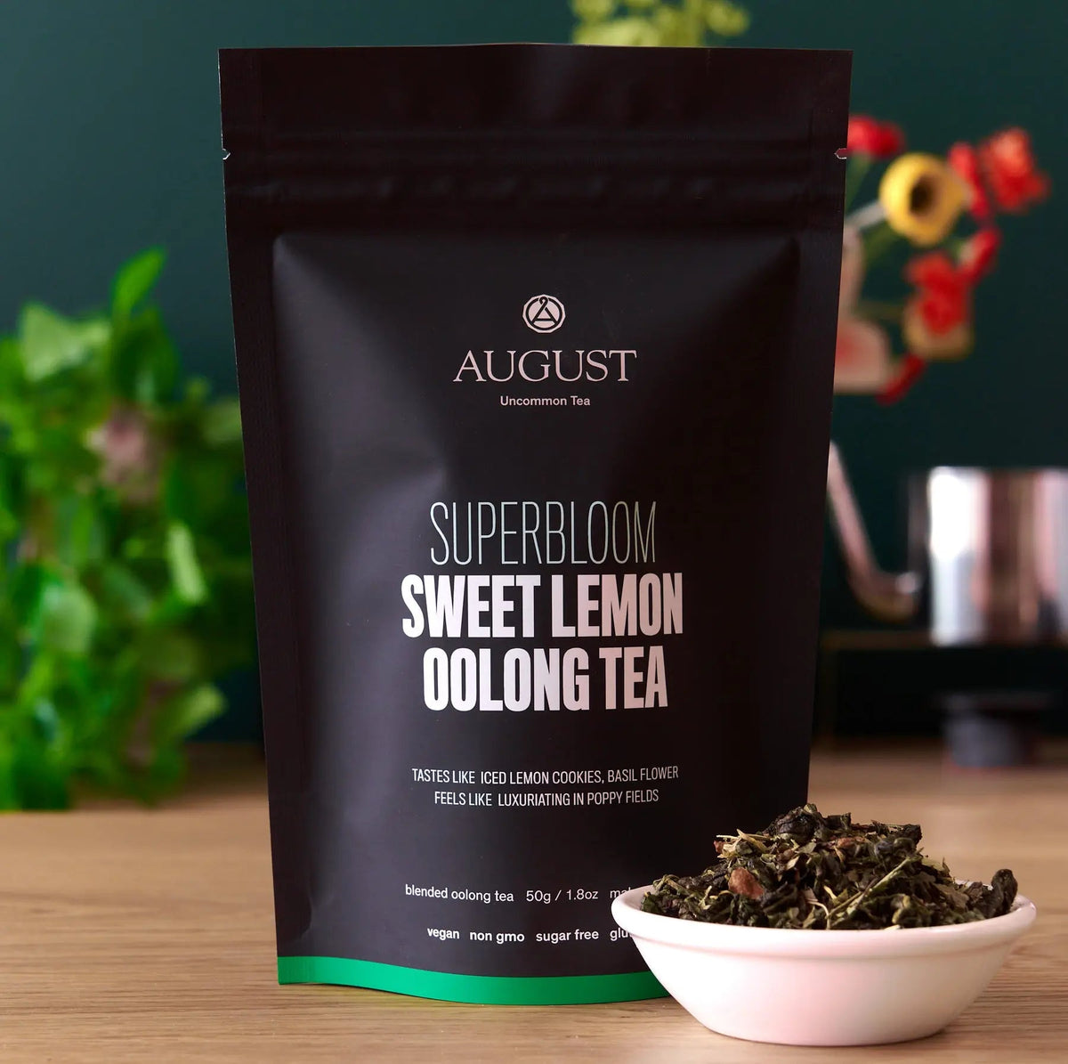 Black tea pouch with Sweet Lemon Oolong Tea front label and small bowl of loose tea leaves
