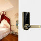 Bronze electronic door lock with touch keypad and lever handle installed on door