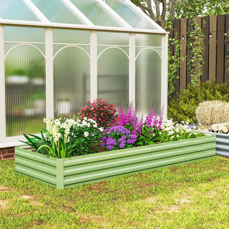 Light green galvanized raised garden bed with mixed flowers and green foliage